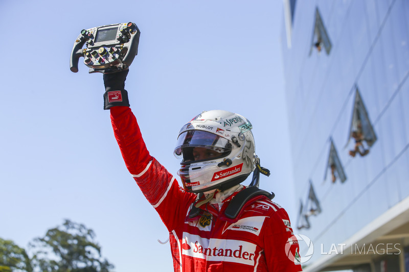 El ganador de la carrera de Brasil, Sebastian Vettel, Ferrari, sujeta el volante de su coche