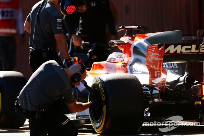 Un ingeniero de Pirelli comprueba un neumático en el Fernando Alonso McLaren MCL32