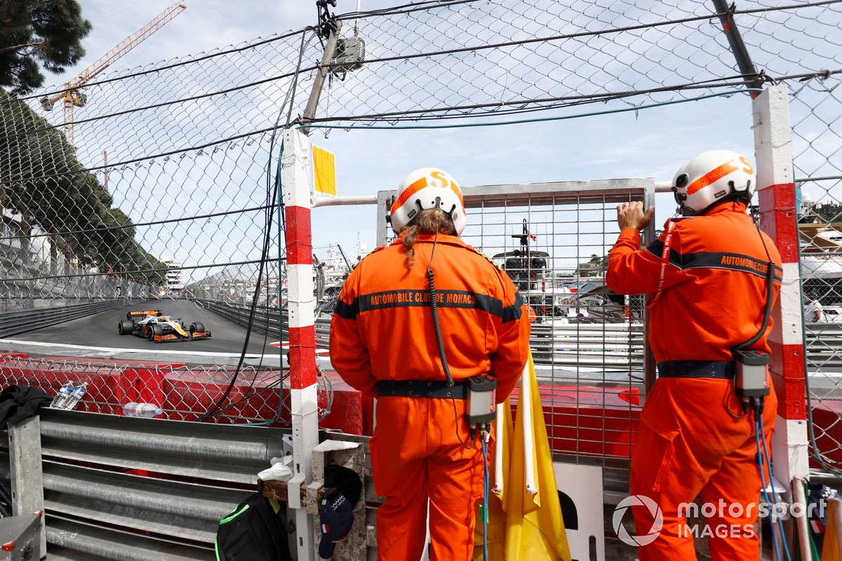 Marshals watch as Daniel Ricciardo, McLaren MCL35M, passes