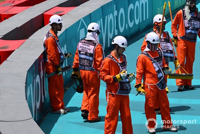 Los comisarios retiran el coche de Lando Norris, McLaren MCL38, después de que hiciera un trompo en la primera vuelta