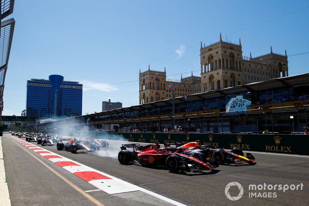 Sergio Pérez, Red Bull Racing RB18, adelanta a Charles Leclerc, Ferrari F1-75 por el liderato en la salida.  Le siguen Max Verstappen, Red Bull Racing RB18 y Carlos Sainz, Ferrari F1-75