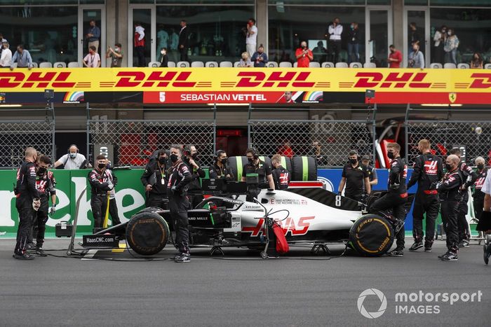 Los mecánicos de Haas F1 en la parrilla con el coche de Romain Grosjean, Haas VF-20