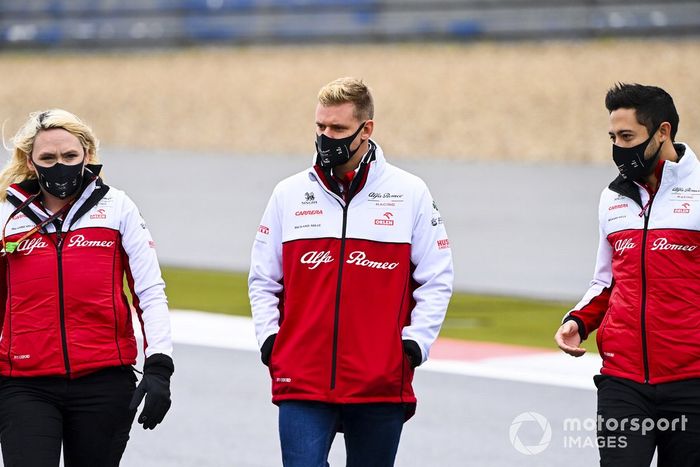 Mick Schumacher, Alfa Romeo, recorre la pista con miembros del equipo