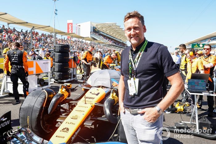 El golfista Ian Poulter posa delante del coche de Lando Norris, McLaren MCL38, en la parrilla de salida 
