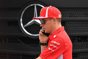 Kimi Raikkonen, Ferrari au téléphone devant un logo Mercedes