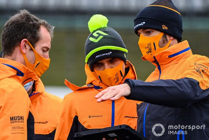 Lando Norris, McLaren, recorre la pista con miembros del equipo