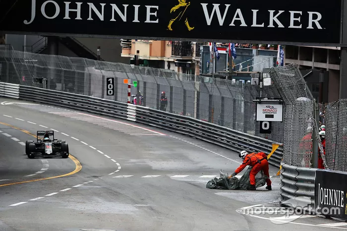 Un commissaire enlève des débris du circuit