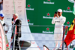 Race winner Lewis Hamilton, Mercedes AMG F1, takes a photo from the podium