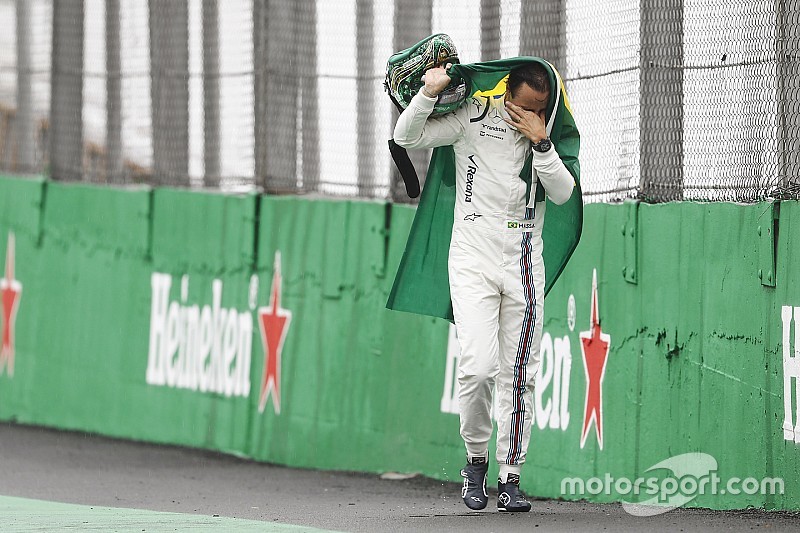 Felipe Massa, Williams, walks back to the garage in tears carrying a Brazilian flag afer crashing