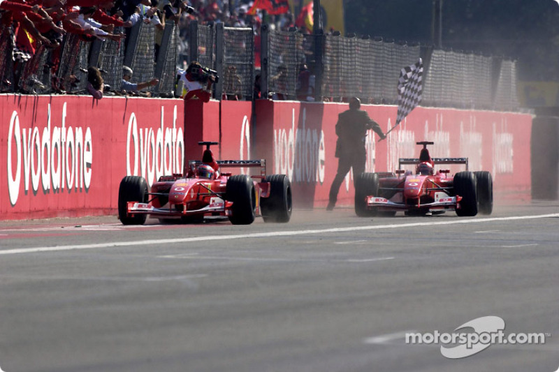 Rubens Barrichello tomando la bandera a cuadros delante de Michael Schumacher