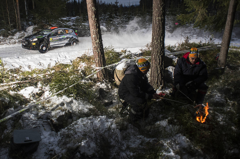 Fans maken een vuurtje, Lorenzo Bertelli passeert in de Ford Fiesta RS WRC