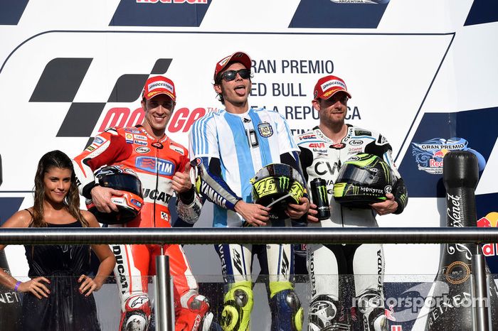 Rossi celebra la victoria en el podio con la camiseta de Maradona, junto a Dovizioso y Cal Crutchlow