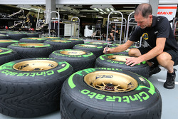 Un mécanicien Lotus F1 Team avec des pneus Pirelli